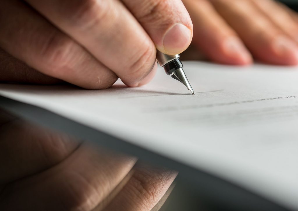 Cliente firmando el contrato para seguros de responsabilidad civil
